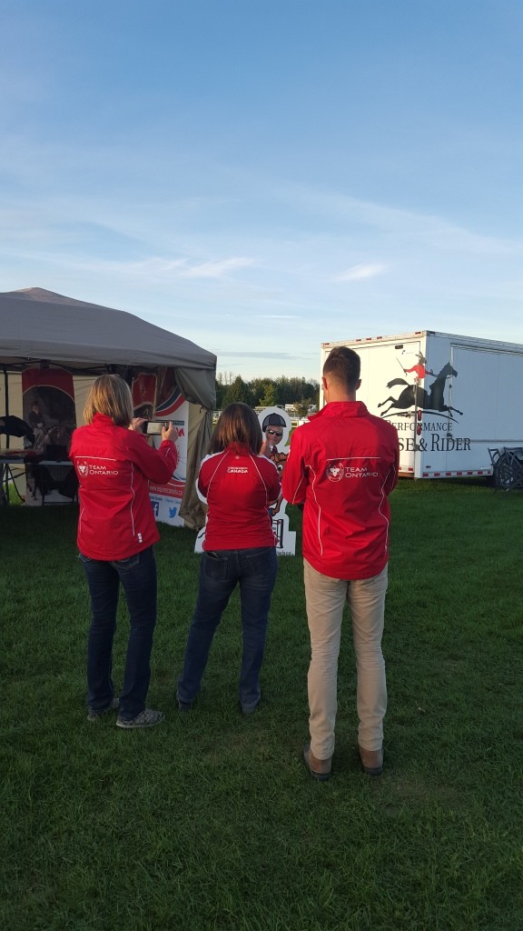 Ellen Dvorak, Simone Williams and Brandon Hall, enjoying taking a picture of Tom Dvorak in the Equine Canada Horse display!