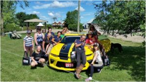 Supermodel poses with the fancy cars - Team Oakhurst does it with style.