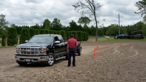 Janan Steward carefully backing the Bean Cars Truck and Trailer through the pylon course being coached by Keith Bean - anyone who completed the backing up received a gift bag with a baseball hat, t-shirt and coupon towards an oil change!